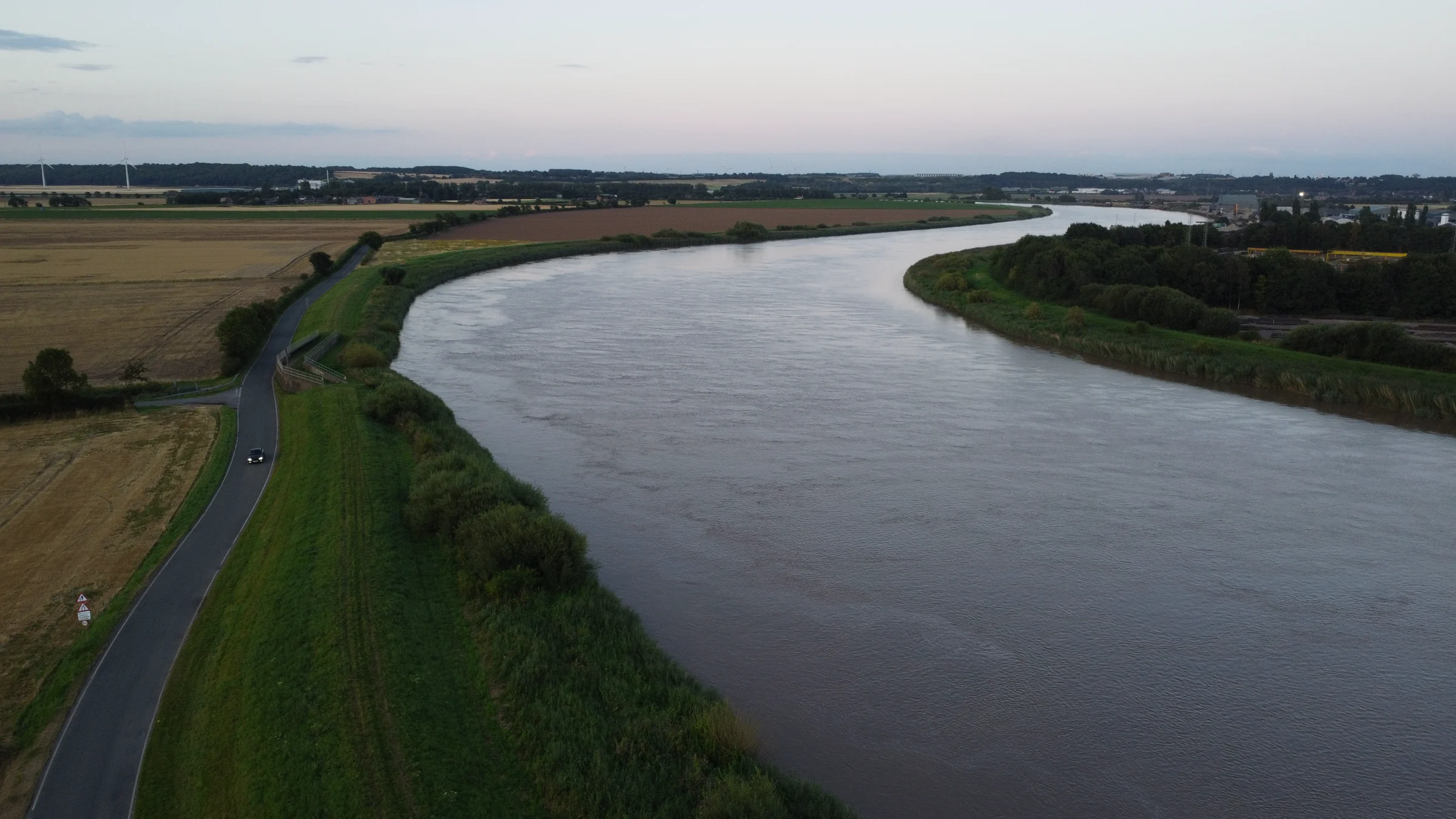Aerial view of the River Trent curving between green banks and harvested fields at dusk
