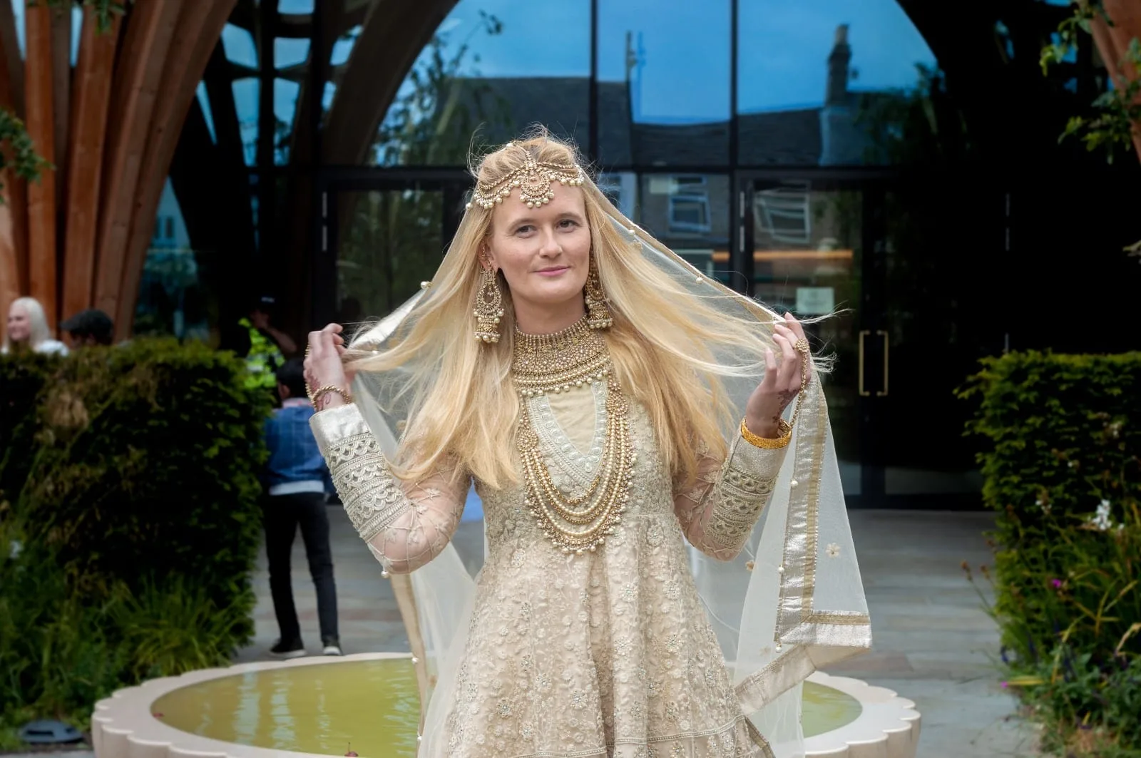 Bride in an ivory wedding outfit and gold jewellery
