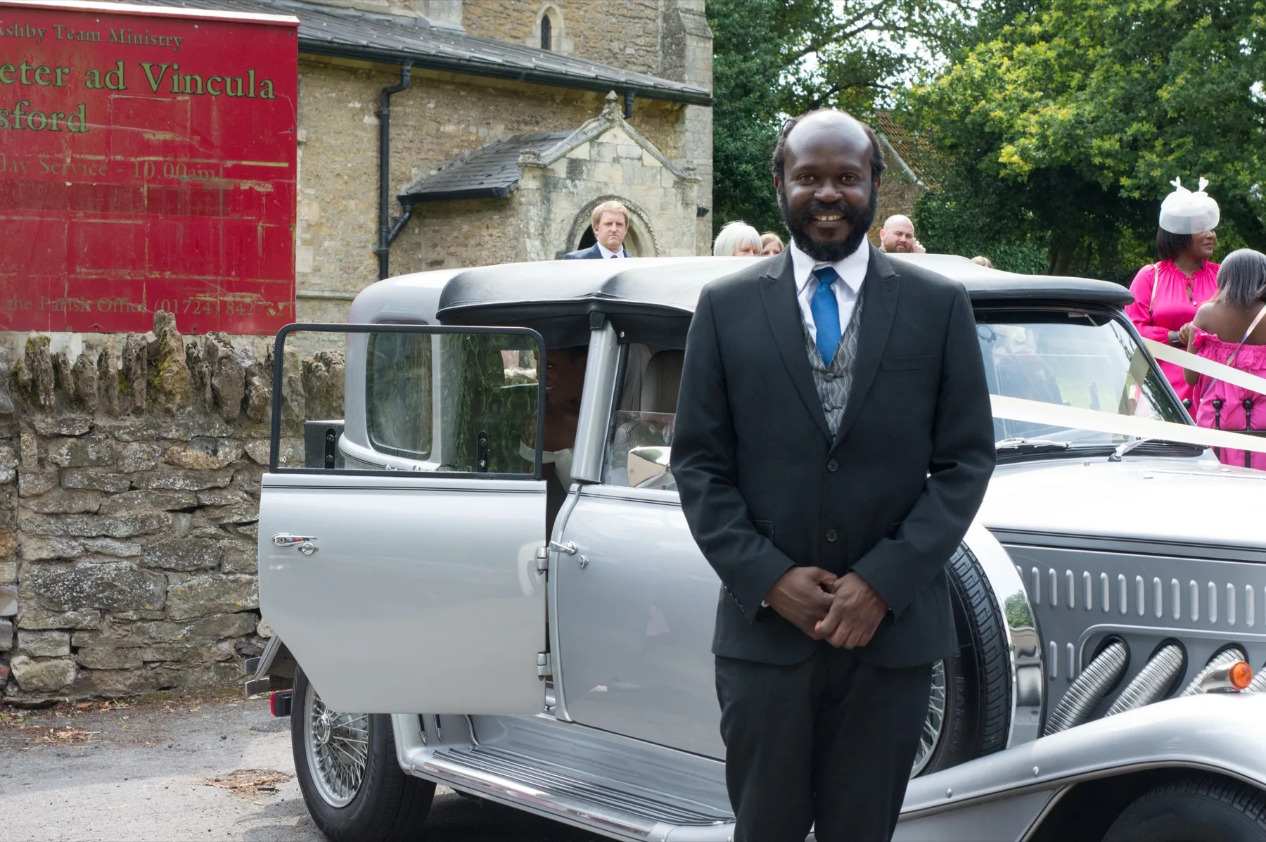 Wedding guest standing beside the wedding car outside the church