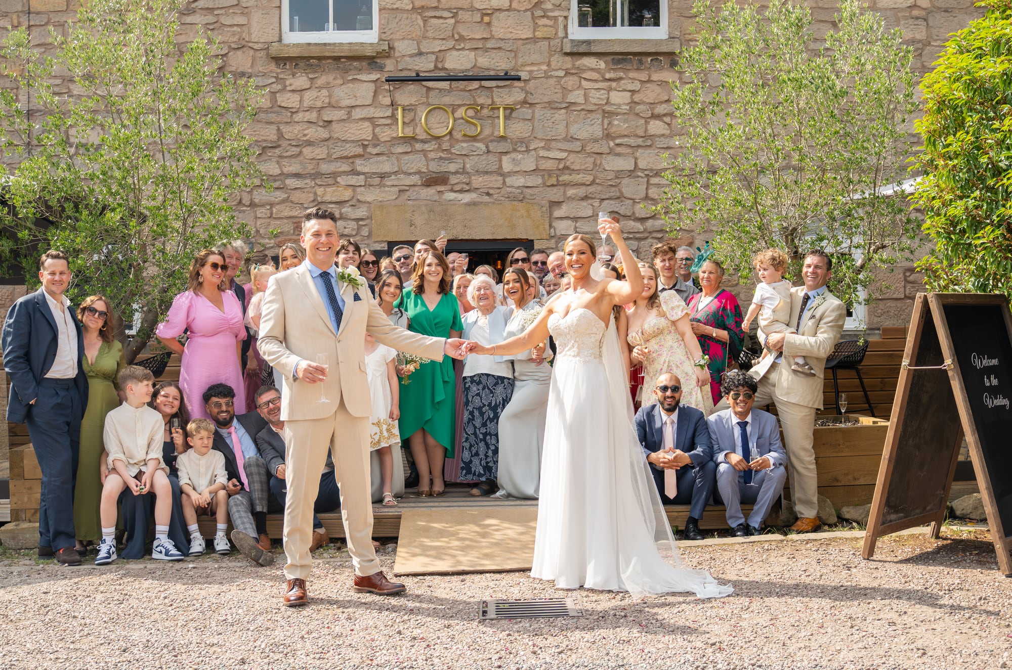 Marcus and Emma with their family and friends outside the wedding venue
