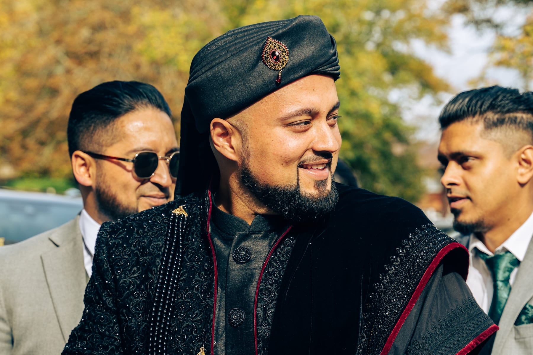 Groom smiling with friends outside the wedding venue
